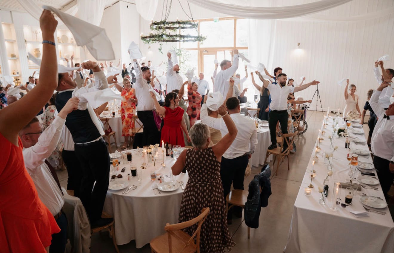 Wedding guests waving napkins during a reception celebration